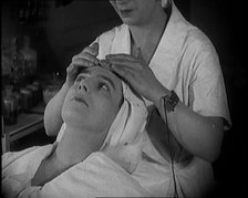 Female Civilian Having Her Face Massaged by Another Female Civilian Wearing an Electric, ... 1920. Creator: British Pathe Ltd.