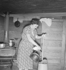 Wife of tobacco sharecropper cleaning butter churn, Person County, North Carolina, 1939. Creator: Dorothea Lange.