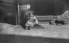 Small child sitting on a doorstep, Chinatown, San Francisco, between 1896 and 1906. Creator: Arnold Genthe.