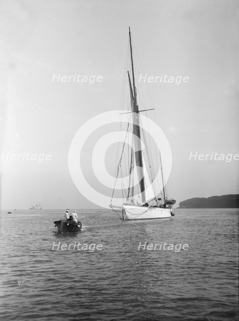 Sailing yacht 'Bona' being towed, 1912. Creator: Kirk & Sons of Cowes.