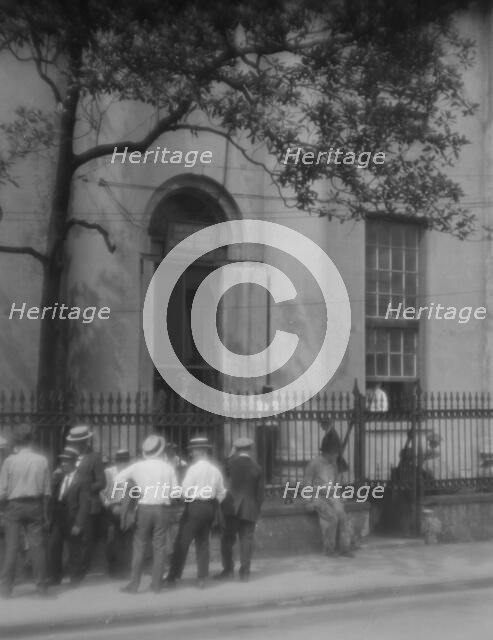 Men standing or sitting in front of the former Bank of Louisiana, 334 Royal Street..., c1920-1926. Creator: Arnold Genthe.