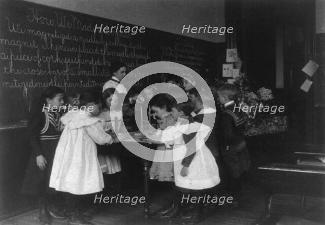 Children in school in Washington, D.C. - learning how a compass is made, (1899?). Creator: Frances Benjamin Johnston.