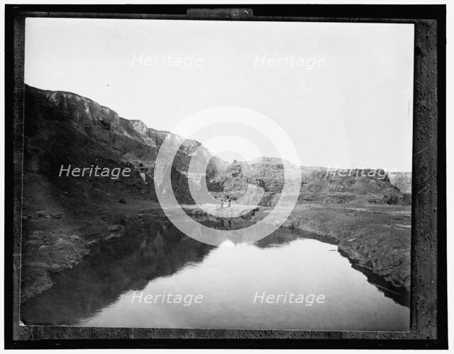 Two women by water, rocky cliffs in background, between 1900 and 1906. Creator: Unknown.