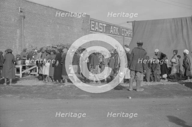 Possibly: Negroes at mealtime in the flood refugee camp, Forrest City, Arkansas, 1937. Creator: Walker Evans.