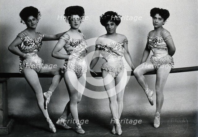 Four young woman acrobats (?), posing on a bar in a photographic studio, between 1899 and 1908. Creator: Unknown.