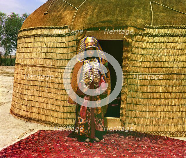 Woman in traditional dress and jewelry standing on rug in front of yurt, between 1905 and 1915. Creator: Sergey Mikhaylovich Prokudin-Gorsky.