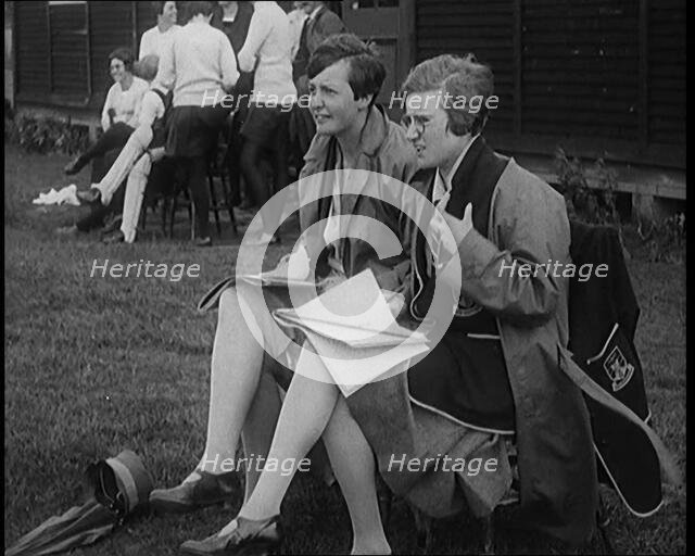 Two Female Civilians Wearing School Uniforms Taking Notes on a Notepad on the Side of a..., 1920. Creator: British Pathe Ltd.