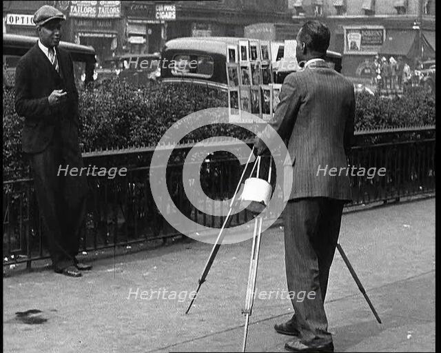 Photographer Taking a Picture of People On the Streets of New York City, 1932. Creator: British Pathe Ltd.