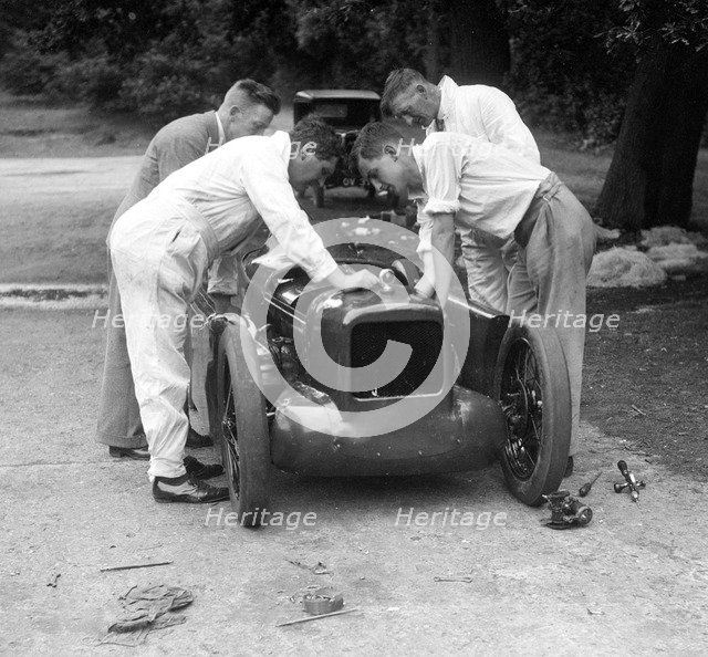 Mechanics working on Leon Cushman's Austin 7 racer for a speed record attempt, Brooklands, 1931. Artist: Bill Brunell.