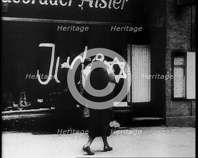 Civilians Looking at  Shop Window with Graffiti Reading: ‘Juden’ on it, 1933. Creator: British Pathe Ltd.