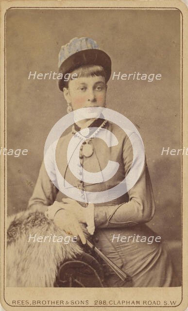 Unidentified woman standing, holding a fan, 1879. Creator: David Rees & Brother & Son.