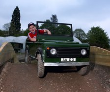 Child driving a toy Land Rover. Artist: Unknown.