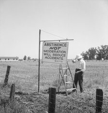 Member of the committee...erects sign on U.S. 99 highway, near Hanford, California, 1939. Creator: Dorothea Lange.