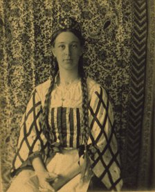 Portrait of a woman with braids in front of a paisley backdrop, c1900. Creator: Frances S. Allen.