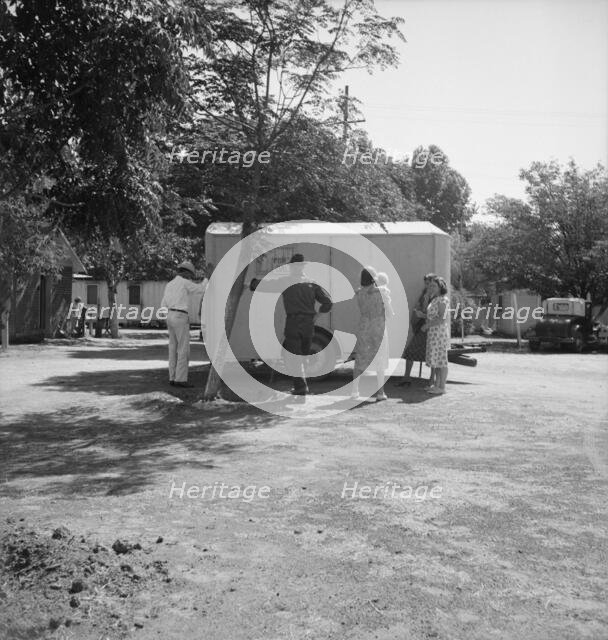 Family inspect a house trailer with idea of purchase, between Tulare and Fresno on U.S. 99, 1939. Creator: Dorothea Lange.