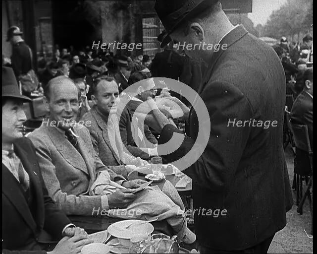 French Police Checking People's Papers Outside a Cafe in Paris, 1940. Creator: British Pathe Ltd.