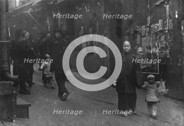 Woman and a child walking down a street, Chinatown, San Francisco, between 1896 and 1906. Creator: Arnold Genthe.