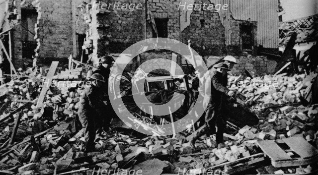 'South Wales had its turn early in the New Year. A stretcher party carries a casualty to safety', 19 Artist: Unknown.