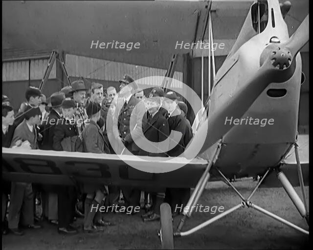 A Group of Male Children Standing Next To an RAF Officer and an Aeroplane, 1931. Creator: British Pathe Ltd.