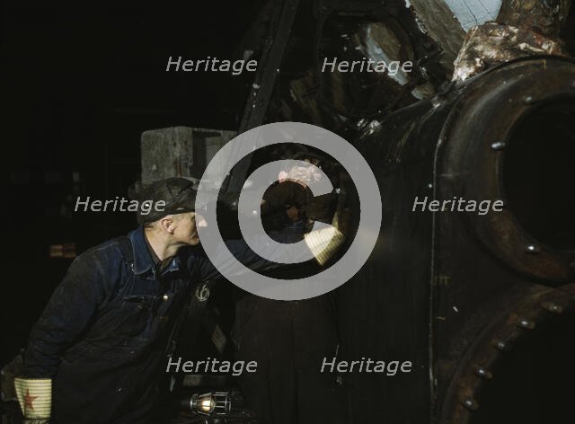 Working on the cylinder of a locomotive at the C & NW RR, 40th Street shops, Chicago, Ill., 1942. Creator: Jack Delano.