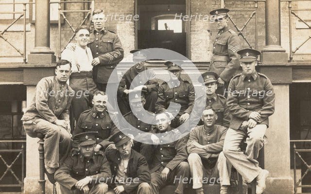Soldiers posing for a group portrait outside a large building, c1910s. Creator: Unknown.