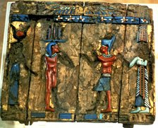 Side of a wooden box with deified human figures in polychromed stone.