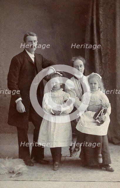 Unidentified family with two girls holding dolls. Creator: Priyalalls Photography.