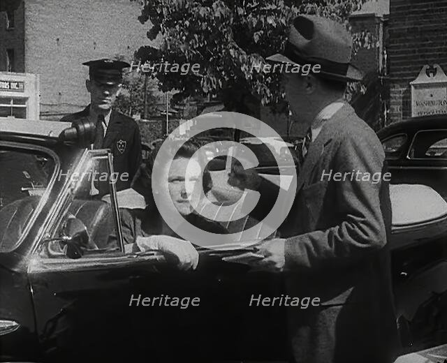 An Official Checking a Petrol Ration Card in Washington, District of Columbia, 1942. Creator: British Pathe Ltd.