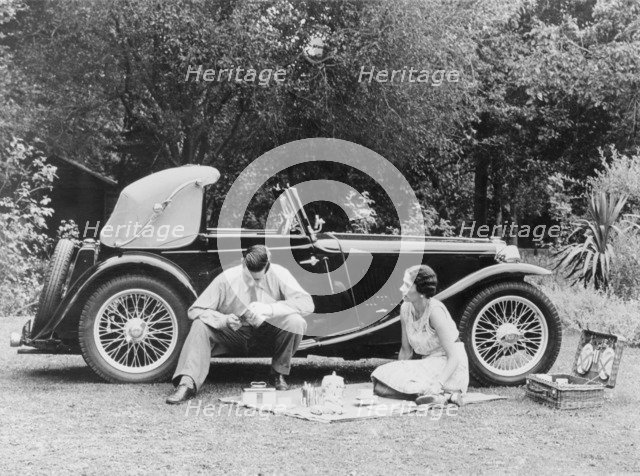 Couple having a picnic by an MG TA Midget, late 1930s. Artist: Unknown
