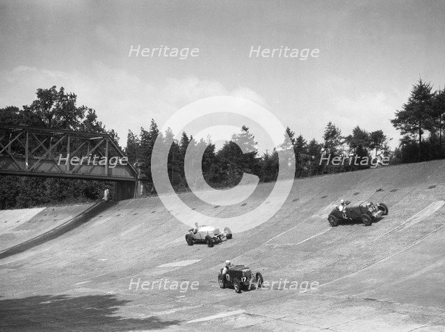 Lea-Francis 1496 cc, MG M type and Invicta 4467 cc racing on the Members Banking at Brooklands. Artist: Bill Brunell.