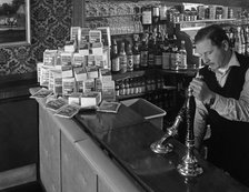 A pub landlord with a display of the Batchelors 5 day catering pack on his bar, 1968. Artist: Michael Walters