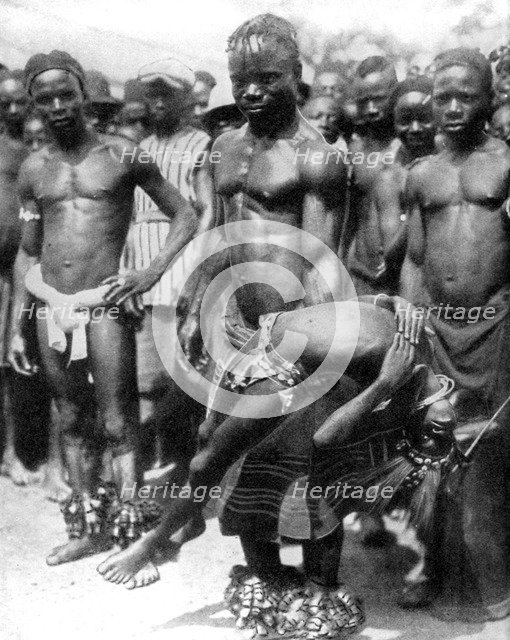 A Yafouba tribesman juggles with a girl, Ivory Coast, West Africa, 1936.Artist: Wide World Photos