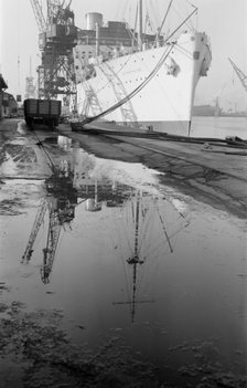 The 'Strathaird' reflected in a puddle at Tilbury Docks, Essex, c1945-c1965. Artist: SW Rawlings