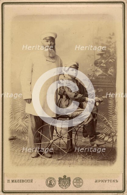 Portrait of an unknown man with a boy sitting on a bicycle, end of 19th century. Creator: PA Milevskii.