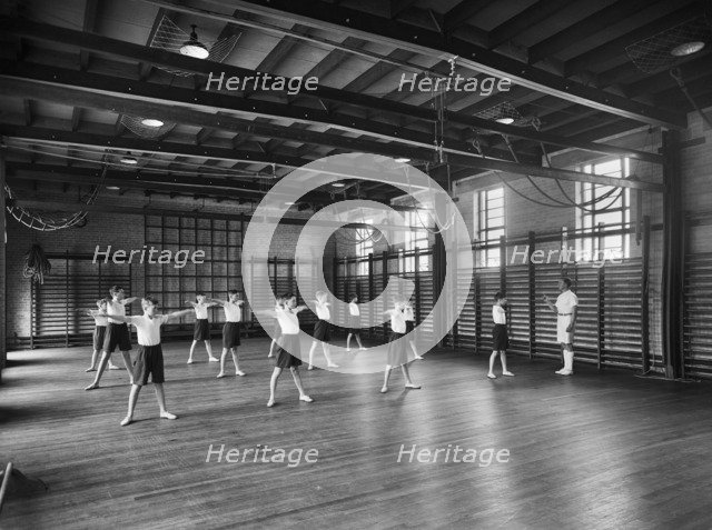Physical Education in the gymnasium, Merchant Taylors School, Northwood, Hertfordshire, 1933-1939 Artist: Marshall Keene and Company.