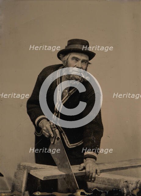 Carpenter Sawing a Plank of Wood, 1880s-90s. Creator: Unknown.