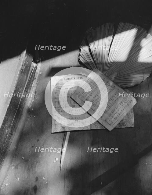Song sheets and a fan left behind in an abandoned church on Independence Ave, Washington, D.C, 1942. Creator: Gordon Parks.