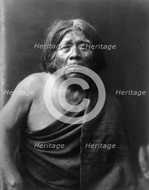 Mat Stams-Maricopa, half-length portrait, facing front, wrapped in blanket, c1907. Creator: Edward Sheriff Curtis.