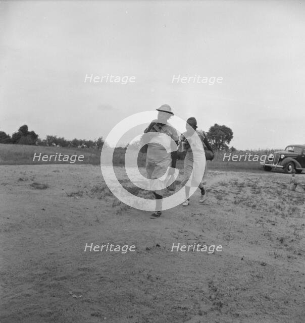 Mother of sharecropper family and friend...in the rain, Person County, North Carolina, 1939. Creator: Dorothea Lange.
