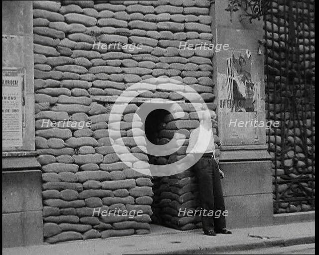 A Man Standing Outside the Frontage of a Building Obscured By Sandbags Next To an..., 1937. Creator: British Pathe Ltd.