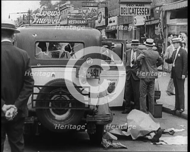 Crowded New York City Street Where Police and Ambulance Attend to Dead and Dying Victims..., 1932. Creator: British Pathe Ltd.