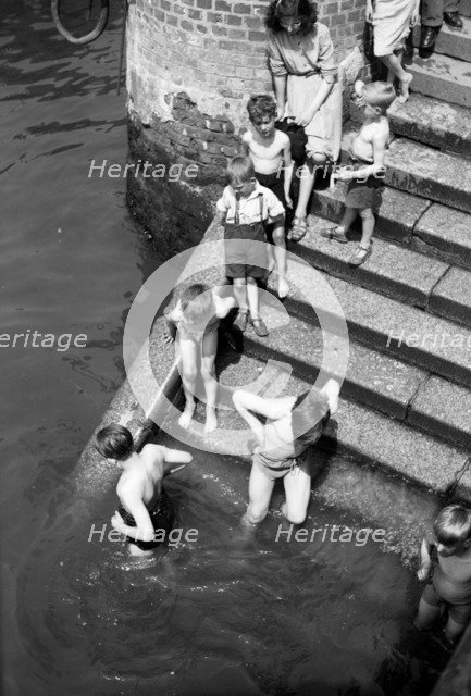Children bathing in the River Thames, Tower Pier approach, Stepney, London, c1945-c1965. Artist: SW Rawlings