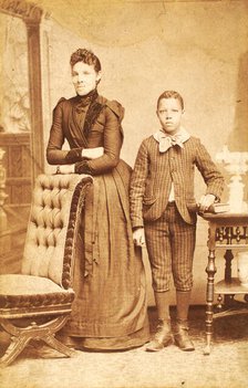 Unidentified standing figures: woman, her folded arms leaning on back of chair..., 1890. Creator: J. N. Wilson.