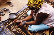Woman painting with mud from the River Niger, Djenné, Mali, 1990. Creator: Amanda Waite.