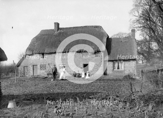 A family pose outside their thatched cottage at Hatford, Oxfordshire, c1860-c1922. Artist: Henry Taunt