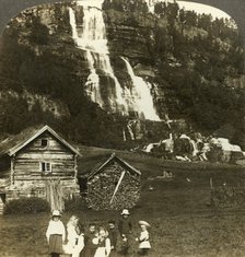 'Children at play in a farmer's field with terraced Tvinde waterfall, Vossevangen, Norway', c1905. Creator: Unknown.