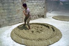 Treading clay for pottery in Tunisia. Artist: CM Dixon Artist: Unknown