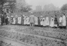 Lady Henry and T.P. O'Connor distribute cabbages, 1913. Creator: Bain News Service.