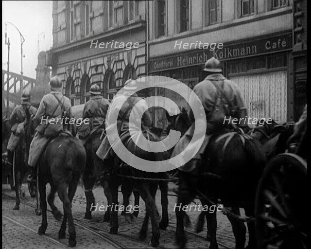 French Soldiers on Horseback Ride Past the 'Heinrich Kolkmann Cafe', 1924. Creator: British Pathe Ltd.