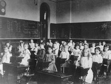 Girls and boys seated at desks in classroom, Washington, D.C., (1899?). Creator: Frances Benjamin Johnston.